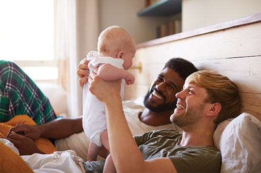 Male couple holds a baby